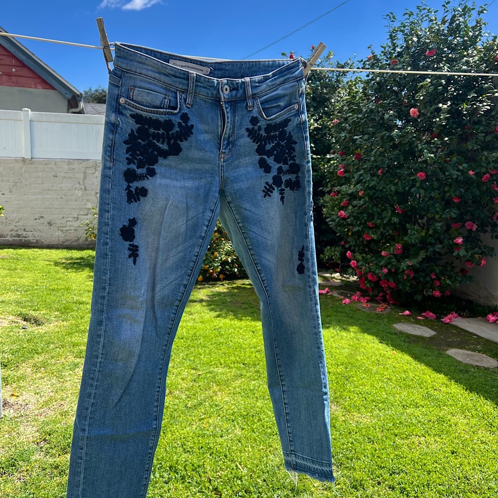 Pilcro & the Letterpress jeans with navy blue floral embroidery and raw hems